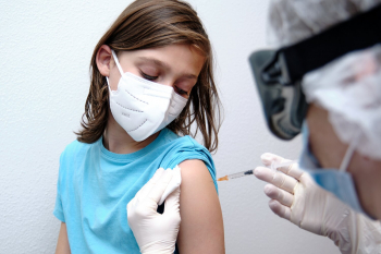 female doctor giving covid 19 vaccine to a boy